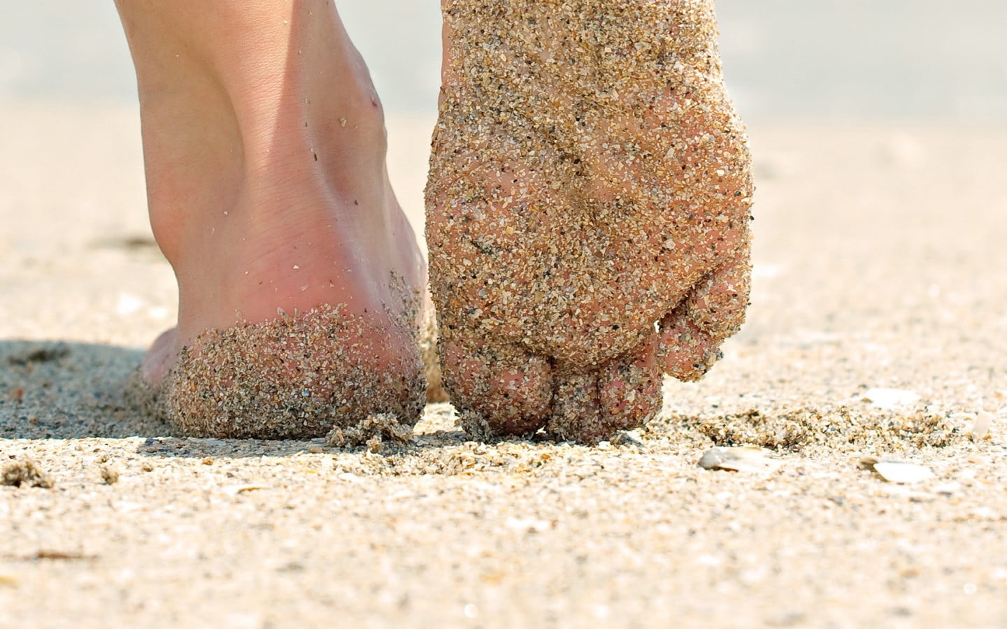 Голая девушка босиком на песке 