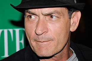 gray haired man wearing black fedora