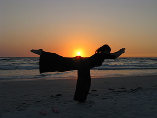 silhouette of woman doing yoga during sunset on beach HD wallpaper