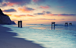 pillars on shore, sunset, sea, nature, sky HD wallpaper