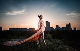 woman wears brown sleeveless dress on green leaf grass photo