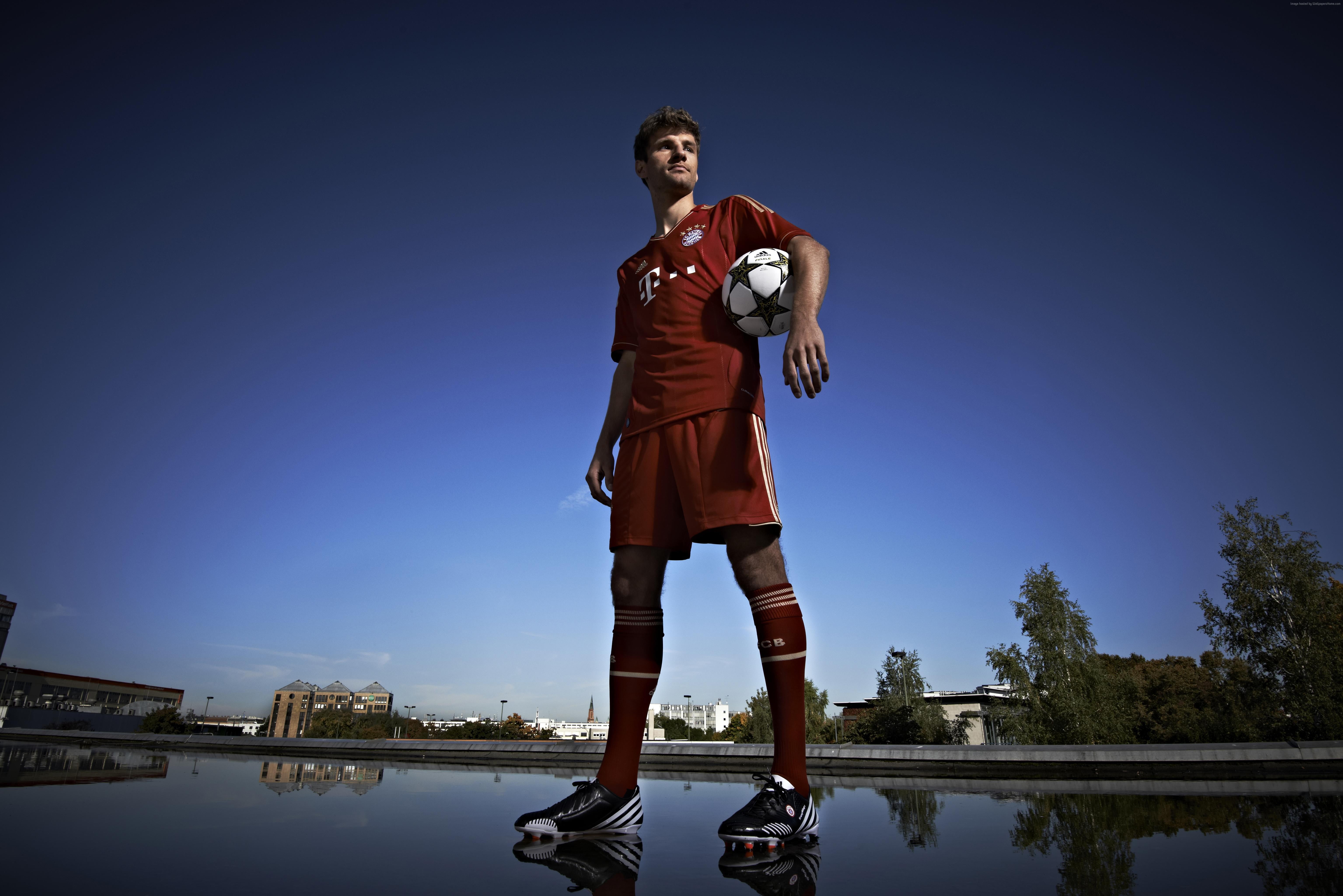 man in red soccer jersey shirt and short holding white ball