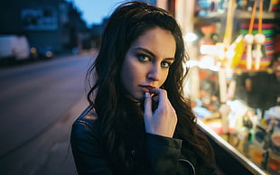 woman wearing black top with right hand on lips