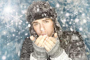 man wearing black fur hooded jacket blowing snowflakes HD wallpaper
