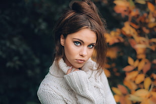 woman wearing white sweater on front of yellow fallen leaves