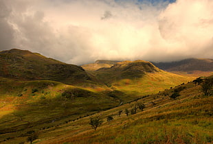 green mountains under cloudy sky at daytime