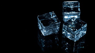 two black-and-gray car mats, ice cubes, dark background, minimalism