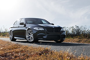 photo of black BMW sedan on gray concrete road during daytime HD wallpaper