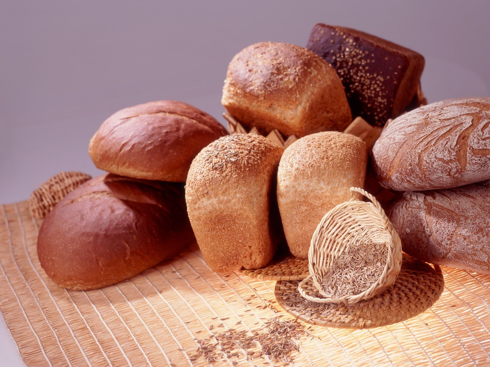 bunch of breads beside white basket on mat