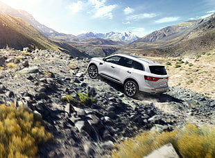 white SUV climbing on rocky hill