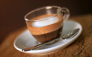 clear glass cup on ceramic saucer