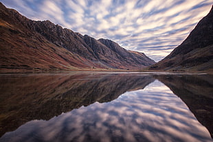 lake near brown mountains under cloudy sky, aonach eagach