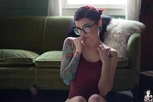 woman wearing maroon tank top and black eyeglasses near sofa HD wallpaper