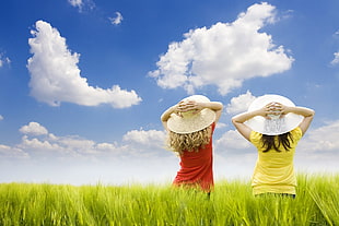 landscape photography of two females on green grass field wearing sun hats HD wallpaper