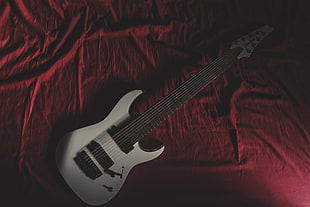 white electric guitar on red textile