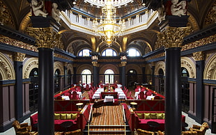 red tables and chair with gold-colored chandelier