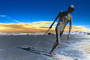 close up photo of person pulling bar statue