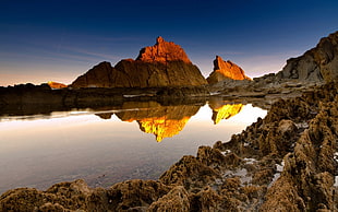 photo of rock formation near body of water