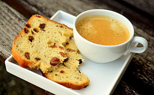 coffee on cup and two slices of bread on plate