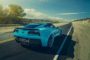 white Chevrolet Corvette sport coupe on gray asphalt road during daytime