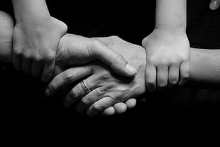 black and white photo of four person hand