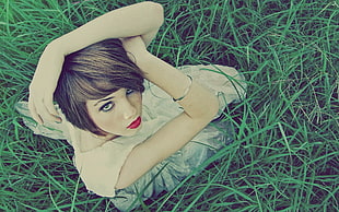 woman wearing white dress kneeling on grass field