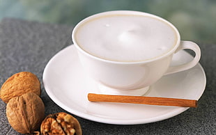 white ceramic tea cup and saucer on table