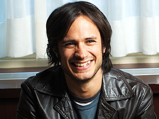 smiling man wearing black leather top HD wallpaper