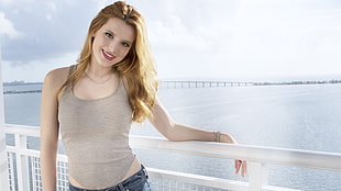 woman standing holding wall smiling