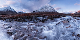 time laps photo of river in front of snowy mountain