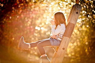 girl in white top sitting on a ladder