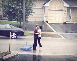 male and female kissing on concrete road