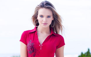 woman wearing red polo shirt while posing on camera