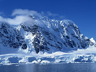 mountain coated with snow under blue sky