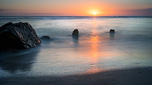 landscape photography of ocean with stone formations during golden hour, madeira beach, florida HD wallpaper