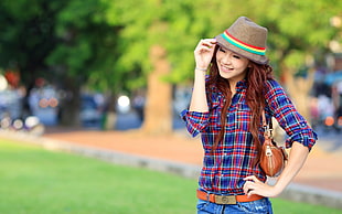 selective focus of woman wearing plaid shirt and holding brown cap HD wallpaper