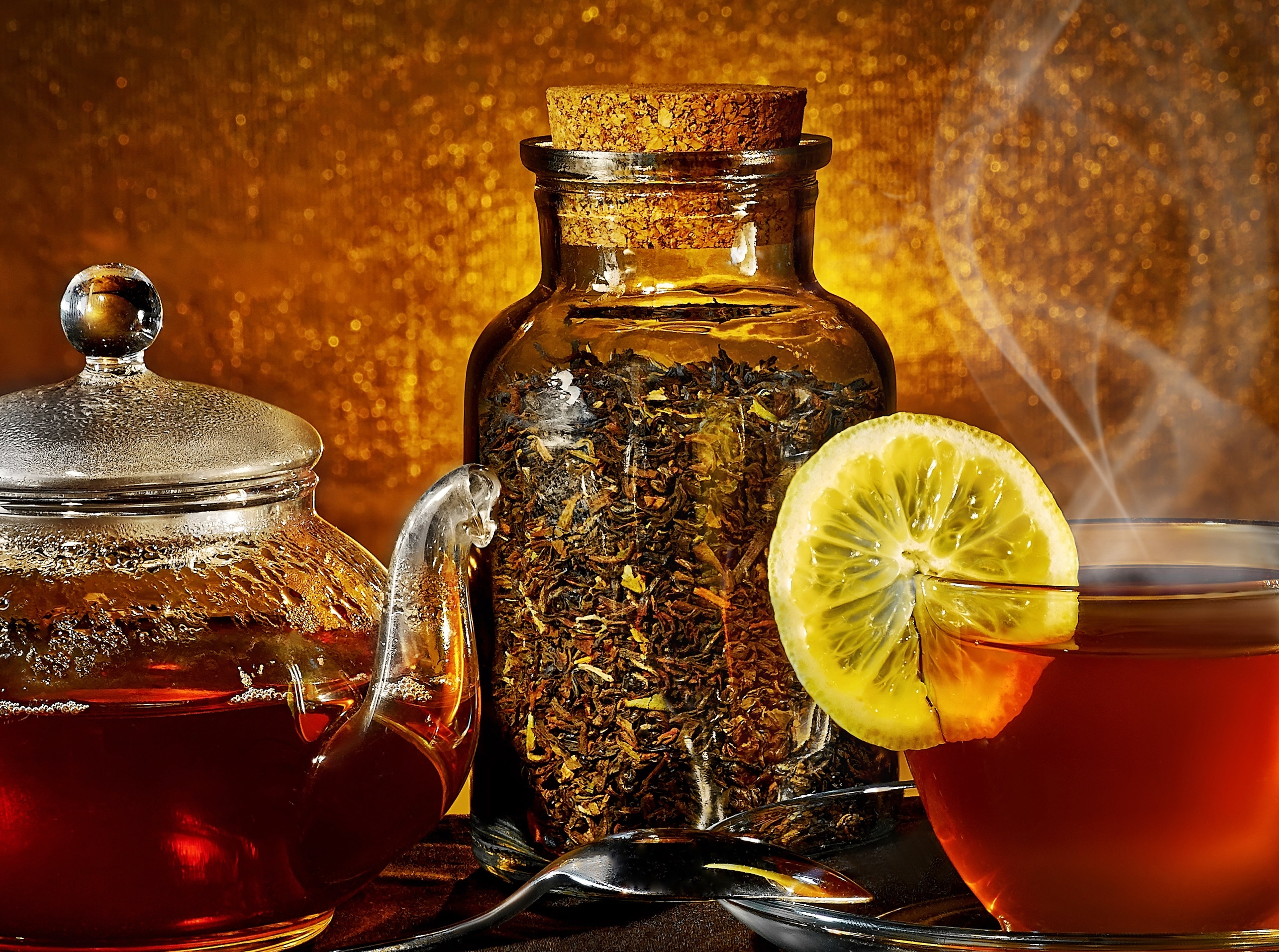 clear drinking glass with sliced lime filled with tea in front of teapot