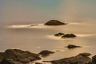 rocks on body of water during daytime HD wallpaper