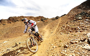 man wearing white racing suit riding on brown full-suspension mountain bike HD wallpaper
