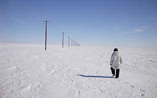 man walking on snow near post HD wallpaper