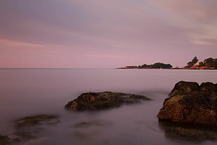 ocean wave on rocks under gray clouds HD wallpaper