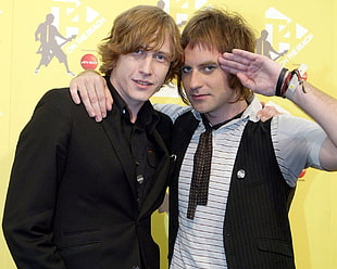 man wearing black dress shirt beside man wearing white and black collared shirt