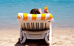 woman lying on the lounger near the beach at daytime HD wallpaper