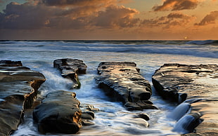 rippling body of water at the rock shore