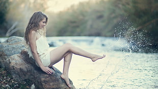 time lapse photograph of woman sitting on rock with water splash HD wallpaper