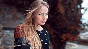 woman in white and black floral shirt smiling for photo