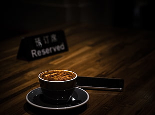 black ceramic cup filled with brown liquid