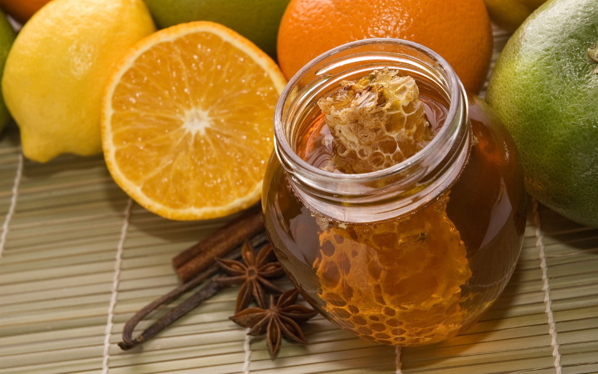 honeycomb in clear glass bowl surrounded of fruits