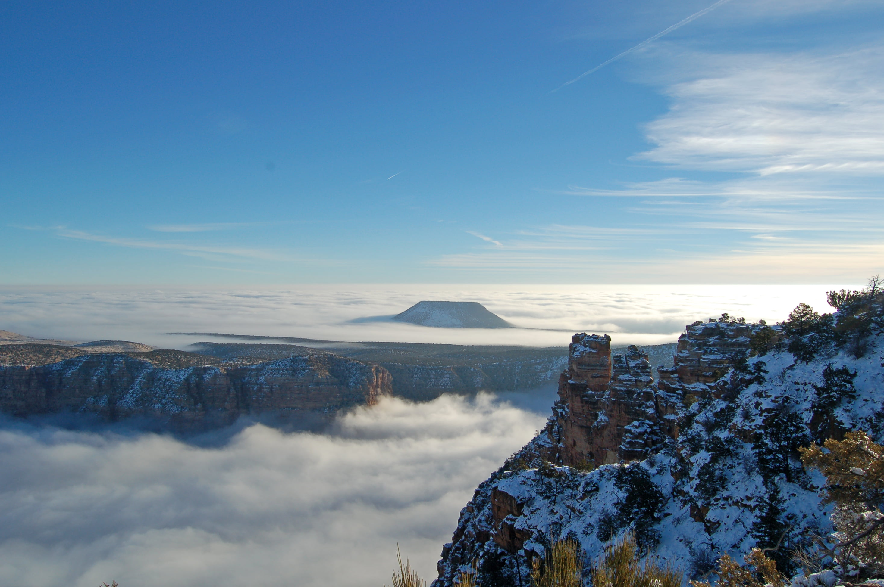 Brown snow covered mountain surrounded by sea of clouds during daytime ...