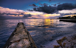 landscape photography or rock formation near body of water during sunset